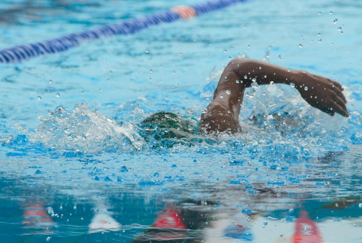 Athlete swimming freestyle in a clear pool with splash and motion